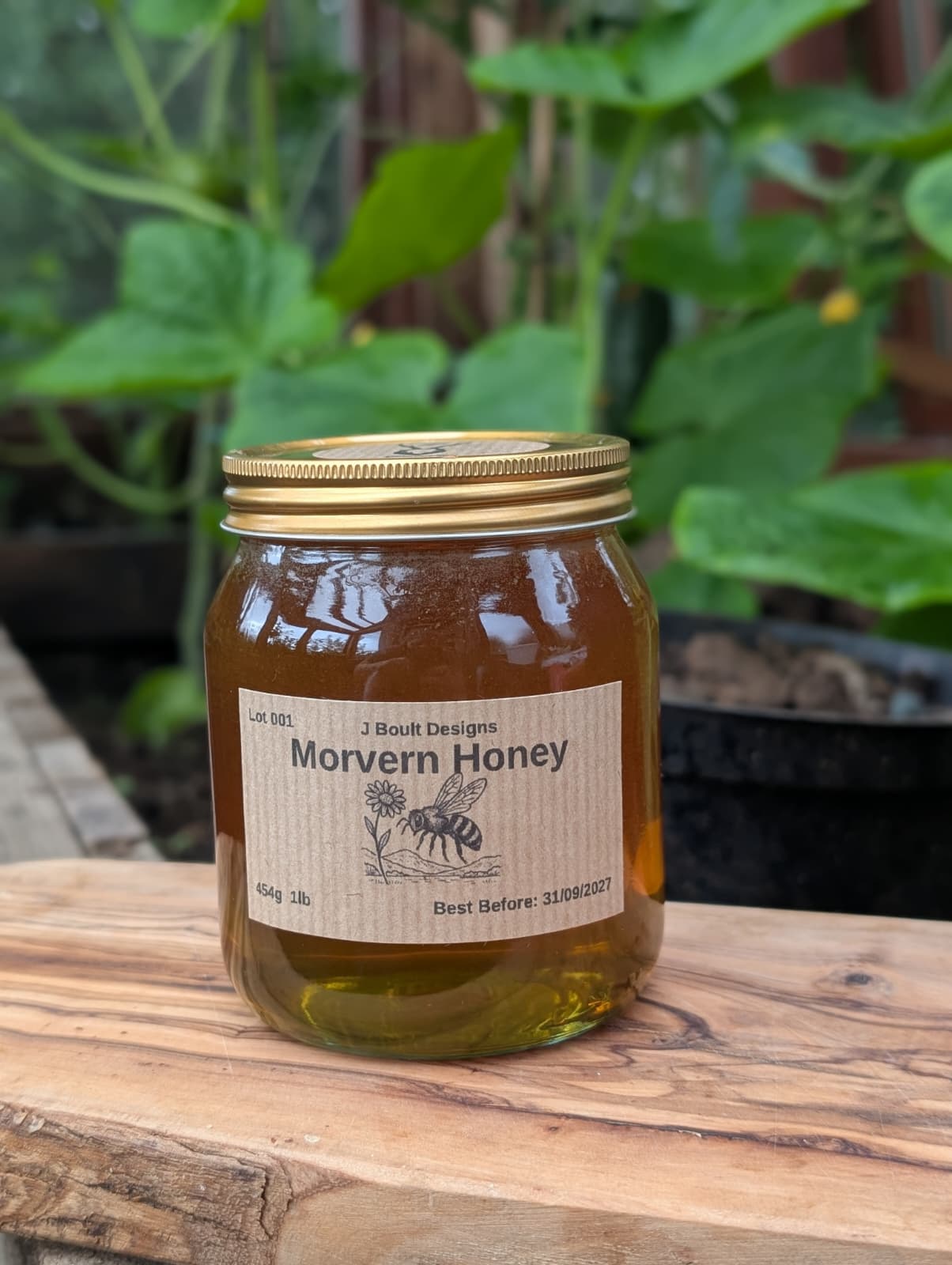 Jar of Morvern Honey on a wooden surface with plants in the background